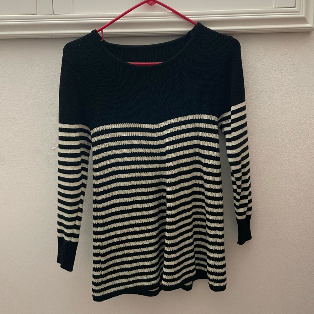 Black knit sweater with white strips. Flairs out at the bottom. Size small